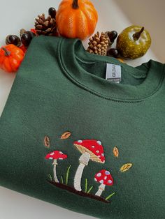 machine embroidered sweatshirt featuring a cute mushroom scene with falling leaves colours pictured are sand and forest green embroidered onto a gildan sweatshirt, composed of 50% cotton and 50% polyester sizing as follows Sizes: S (50,8cm-68,6cm) / M (55,9cm-71,1cm) / L (61cm-73,7cm) / XL (66cm-76,2cm) / XXL ( 71,1cm-78,7cm) these are made to order and i may need to order your preferred size & colour, so please allow time for your sweatshirt to be ready!  if you have any questions or would like