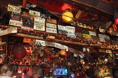 a bar with lots of license plates hanging from the ceiling and people sitting at tables