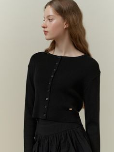 This is a classic cardigan with a simple, chic design. It has a round neckline and a full button placket with small, evenly spaced buttons. The cardigan is designed with a fitted silhouette and long sleeves, suggesting a snug and comfortable fit. A small, discreet logo or emblem is visible on the front, indicating a touch of branding.- Round neckline and full button placket are key features.- Fitted silhouette with long sleeves.- A subtle logo embellishes the front of the cardigan. Chic Crew Neck Sweater With Buttons, Elegant Crew Neck Top With Button Closure, Chic Crew Neck Cardigan, Elegant Crew Neck Top With Buttons, Chic Long Sleeve Cardigan With Button Cuffs, Elegant Crew Neck Fine Knit Outerwear, Elegant Fine Knit Crew Neck Outerwear, Everyday Chic Button-up Cardigan, Elegant Fitted Crew Neck Cardigan