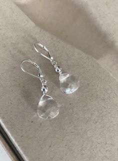 "These clear Swarovski crystal teardrop earrings are available in gold filled or sterling silver.  They are topped with smooth metal beads and dangle from lever backs for a secure wear. Minimalist, dainty and elegant for day or night, they'll easily become your go-to everyday pair!  The earrings measure just over 1.25\" from end to end. The clear crystals are approx 11x10mm. Please make your preferred metal selection from the drop down menu at check out. You may also like to check out more of my Affordable Silver Beaded Crystal Earrings, Elegant Faceted Briolette Crystal Earrings, Elegant Briolette Faceted Crystal Earrings, Elegant Faceted Teardrop Earrings, Elegant Sterling Silver Teardrop Earrings For Everyday, Elegant Briolette Crystal Earrings, Elegant Silver Water Drop Earrings, Classic Sterling Silver Crystal Drop Earrings, Sterling Silver Teardrop Clear Jewelry