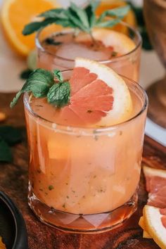 two glasses filled with drinks and garnished with grapefruit