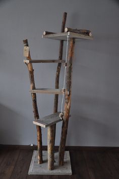 a wooden shelf made out of branches and logs with a ladder attached to the top