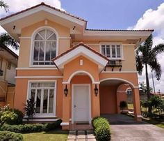 a house that is painted orange and has white trim on the windows, doors, and shutters