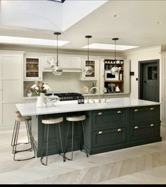 a large kitchen with an island and two stools