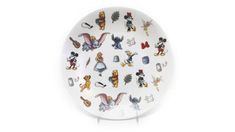 a white plate with many cartoon characters on the front and back of it, all in different colors