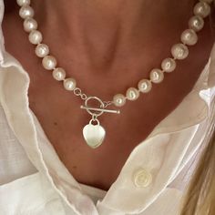 "A beautiful necklace of knitted genuine pearls with a solid sterling heart pendant hanging from  toggle clasp.  An instant classic and great addition to any jewelry collection.  A fantastic gift to give and to receive ❤️ available in 16.5\", 18.5\", 20.5\" lengths.  measurements including the toggle clasp.  heart pendant measures 16 x 20mm, solid 925 sterling silver  the pearls are cultured akoya freshwater pearls, 9-10mm, each will have its own unique variations - no two pearls are the same.  all components are Solid 925 Sterling Silver available without pendant." Silver Toggle Necklace With Pearl Charm Gift, Classic Toggle Necklace With Pearl Charm For Gift, Classic Pearl Charm Toggle Necklace, Silver Toggle Necklace With Pearl Pendant, Silver Toggle Necklace With Pearl Pendant As Gift, Silver Heart Pendant Pearl Necklace, Elegant Silver Toggle Necklace With Heart Charm, Elegant Heart Pendant Toggle Necklace, Silver Pearl Necklace With Heart Pendant