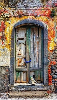 an old wooden door in front of a brick wall