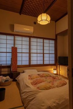 a bed sitting in a bedroom next to a window with lots of light on it