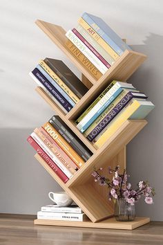 a bookshelf with many books on top of it next to a vase filled with flowers