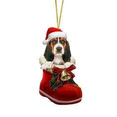 a christmas ornament with a basset hound dog wearing a santa hat and holding a bell