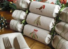 a stack of christmas napkins sitting on top of a table next to a fork and knife