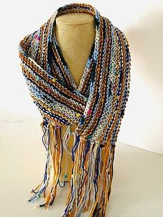 a mannequin wearing a multicolored scarf with fringes and beads on it