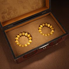 an open box with two yellow beads in it