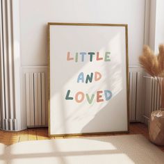 a poster with the words little and loved on it in front of a radiator