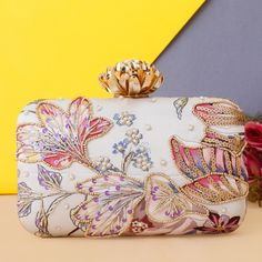 This is a beautiful handcrafted clutch bag made with love.It has intricate handwork which showcases the Indian craftsmanship by our local artisans. It comes with a metal sling chain. Details  - Single side embroidery  - Back side printed  - Fabric lining on the inside to keep your belongings safe  - Metal lock closure  - Detachable sling chain  This clutch can be worn as a crossbody bag or a shoulder bag with the sling chain or can simply be carried in hand.It is spacious enough to carry mobile Multicolor Embroidered Evening Clutch Bag, Multicolor Evening Bags With Handwork, Evening Multicolor Bags With Handwork, Pink Shoulder Bag With Handwork For Party, Chic Hand Embellished Rectangular Evening Bag, Embellished Beige Evening Bag As Gift, Beige Embellished Evening Bag As Gift, White Embroidered Rectangular Evening Bag, Evening Multicolor Embroidered Bag