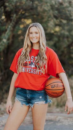 a young woman holding a basketball in her right hand