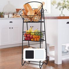 a black metal basket with bread and fruit in it on top of a wooden floor