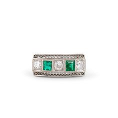 The Story An Art Deco diamond ring from the 1930s, filled with old cut stones. Three Old European Cut diamonds alternate across the front with two old square cut emeralds accenting the piece beautifully. All set in platinum, the colors look incredible together. The back of the settings are open allowing light to flow through creating amazing sparkle with pops of luscious color. With 0.36 carats of diamonds, the platinum design allows for tons of detailing. This gorgeous ring, light and easy to wear. Worn as an engagement ring or a cocktail ring, this beautiful piece is sure to stop you in your tracks. The Specs Style Number: R2531 Vintage, Art Deco circa 1935 Platinum 2 square cut emeralds, each 3.3 mm (approx.) 5 Old European Cut diamonds, 3 measure 0.10 carats each, 2 measure 0.03 carats Vintage Green Diamond Ring With Accents, Vintage Emerald Cut Emerald Ring With Diamond Accents, Vintage Green Diamond Ring In Platinum, Vintage Green Diamond Platinum Ring, Art Deco Multi-stone Emerald Ring For Anniversary, Vintage Green Emerald Ring With Single Cut Diamonds, Heirloom Emerald-cut Ring With Single Cut Diamonds, Heirloom Emerald Cut Ring With Single Cut Diamonds, Vintage Three-stone Emerald Ring For Anniversary