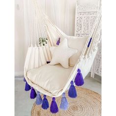 a white hammock with purple tassels and a star on the pillow