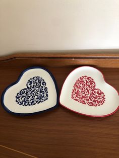 two heart shaped dishes sitting on top of a wooden table