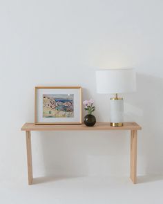 a wooden table with a lamp and painting on it