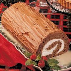 a sliced cake on a plate with frosting and strawberries next to the pie