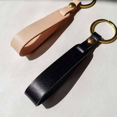 two different types of leather keychains sitting next to each other