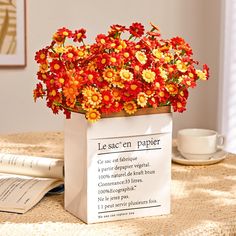 a vase filled with flowers sitting on top of a table next to an open book