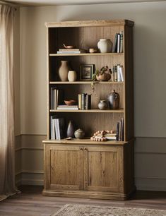 a wooden bookcase filled with lots of books on top of a hard wood floor