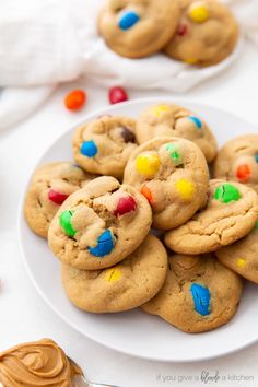 a white plate topped with cookies covered in m and m cookie toppings next to candy