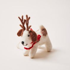 a small white and brown dog with antlers on it's head, wearing a red collar