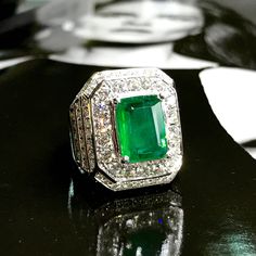 BRAND-NEW!! ONE OF A KIND, HANDCRAFTED RING. EXQUISITE AND FINE CRAFTSMANSHIP! HANDMADE TO LAST FOR AN ETERNITY!! HEIRLOOM PIECE!! PRECIOUS JEWELRY TO BE PASSED ON! ENORMOUS DRESS RING FOR A GENTLEMAN WHO LIKES ATTENTION! 6.91 total carat weight, Certified, Natural emerald ring. This ring offers an important statement of who you are with a 4.15 carats, VIVID GREEN, transparent, ZAMBIAN EMERALD. Accentuating the EMERALD are the 139 F/VS, sparkling natural diamonds SUGGESTED RETAIL VALUE: $18,500 Luxury Diamond-cut Emerald Ring For Formal Occasions, Luxury Emerald Ring With Diamond Cut For Formal Events, Luxury Emerald Ring With Diamond Cut For Formal Occasions, Classic Gia Certified Signet Ring For Formal Occasions, Timeless Emerald Signet Ring For Formal Occasions, Formal Gia Certified White Gold Signet Ring, Formal White Gold Gia Certified Signet Ring, Luxury Hallmarked Emerald Cut Signet Ring, Luxury Green Signet Ring For Formal Occasions