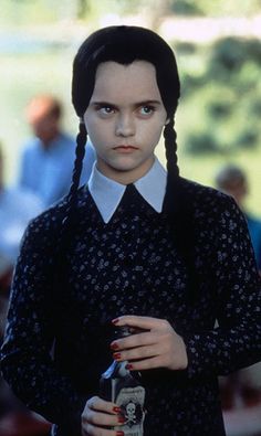 a woman with braids holding a beer in her hand and looking at the camera