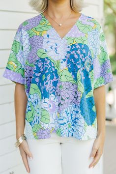 Look no further for a bold outfit statement than the By The Garden Floral Top – it'll have you looking bright and cheery, no matter the occasion! It's casual enough for the weekend, but its bold print will give you the perfect pop of color for your wardrobe. V-neckline Short sleeves Floral print Oversized fit No stretch Payton is wearing the small. Lavender V-neck Top For Vacation, Vibrant Cotton Tops For Spring, Lavender Spring Top, Blue Floral Print Top For Garden Party, Vibrant Floral Print Cotton Tops, Vibrant Cotton Floral Print Top, Lavender Floral Print Top For Vacation, Lavender Tops For Beach In Spring, Lavender Beach Tops For Spring