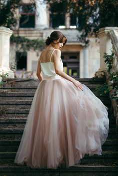 a woman is standing on some steps wearing a dress