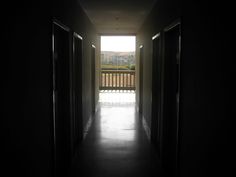 an empty hallway leading to a balcony in the dark