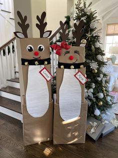 two reindeer bags sitting on top of a wooden floor in front of a christmas tree