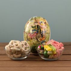 three small bowls filled with different types of candies on top of a wooden table