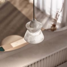 a white lamp hanging from a ceiling in a living room