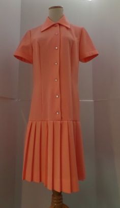 This salmon pink dress is vintage hipster with its dropped waist and accordian pleats. It has a 1920s style with the silhouette. The label is A Yardley Fashion. It is machine washable. Twiggy wore one of Gibbs dresses to her premiere which heightened the popularity of his label. He became perhaps most famous for his extraordinary knitwear designs, undeniably inspired by his Scottish origins. Initially hand machined by Mildred Boulton, who worked from Gibb's designs and Kaffe Fassett's swatches, Pink Fitted A-line Pleated Dress, Vintage A-line Pleated Dress, Fitted Pleated Dress With Box Pleat For Spring, Classic Fitted Pleated Dress With Accordion Pleats, Fitted Pleated Vintage Dress, Pink Fitted Dress With Box Pleat, Knee-length Fitted Pleated Dress For Daywear, Fitted Knee-length Pleated Dress For Daywear, Spring Retro Pleated Vintage Dress