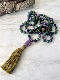 108 Mala beads necklace. DETAILS: 8mm amethyst beads. 8mm Moss Agatebeads. Tassel Necklace length 40 Inches approx. What is a mala? Mala necklaces are very special pieces of jewelry. They are traditionally used in yoga when reciting mantras. One mala usually consists of 108 beads, a guru-bead and a tassel. In Buddhism and Hinduism the number 108 has a special meaning. It is said that a mantra develops its special effect only after 108 repetitions. AMETHYST  Amethyst is a natural tranquiliser, it Spiritual Amethyst Necklace With 108 Beads, Spiritual Amethyst Beaded Necklaces, Spiritual Amethyst Beaded Necklace, Spiritual Purple Polished Beads, Purple Agate Gemstone Beaded Necklace, Spiritual Amethyst Beaded Necklaces With Polished Beads, Spiritual Amethyst Beaded Necklace With Polished Beads, Spiritual Amethyst Gemstone Beaded Necklaces, Spiritual Purple Agate Beaded Necklaces