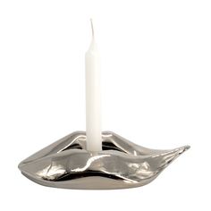 a candle is sitting on top of a silver bowl with a white candle in it