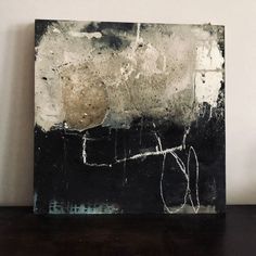 a black and white painting sitting on top of a wooden table