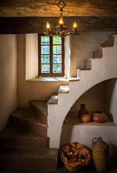 a staircase leading up to a window in an old style house with stone steps and wooden railings