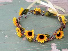 a sunflower headband with leaves and berries on the front, tied in a bow