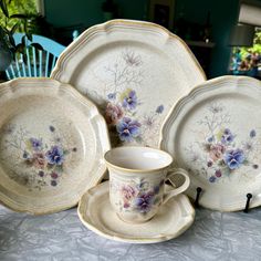 a table topped with plates and cups filled with flowers