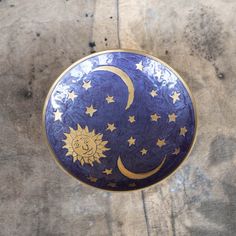 a blue and gold plate with stars and the moon on it is sitting on a table