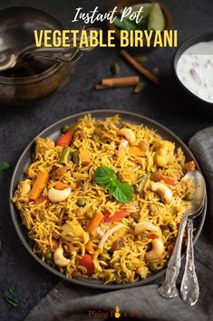 vegetable biriyani served in a bowl with spoons and garnishes