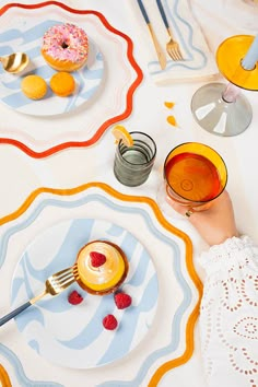 a table with plates, cups and donuts on it