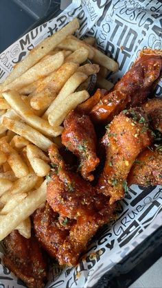 chicken wings, french fries and ketchup on a paper plate with black and white designs